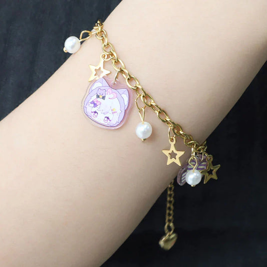 Gold chain acrylic charm bracelet with cartoon animal, star, and pearl accents on wrist
