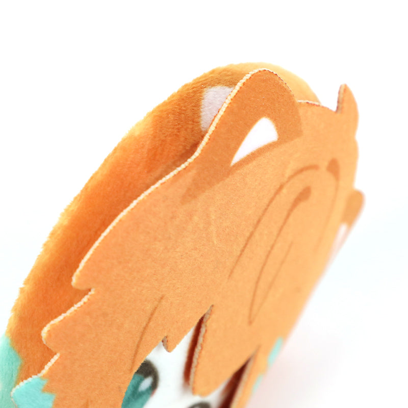 Close-up of custom plush head button pin with orange anime-style hair and blue eyes