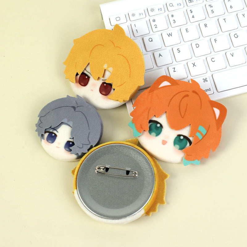 Custom 3D plush anime head button pins with colorful hair next to a white keyboard.