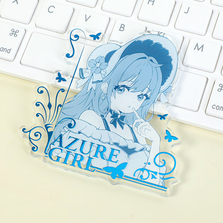 Custom acrylic fridge magnet with anime girl illustration and raised foil stamping near keyboard