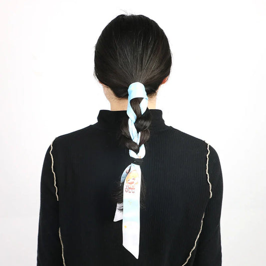 Woman with braided hair using a custom silk scarf with cartoon design as a hair accessory